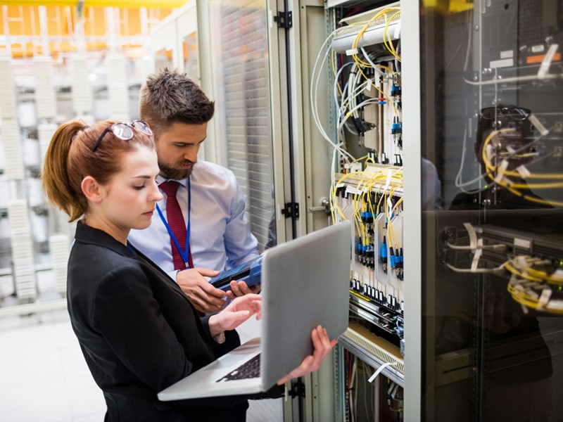 Photo of male and female technicians working on server rack