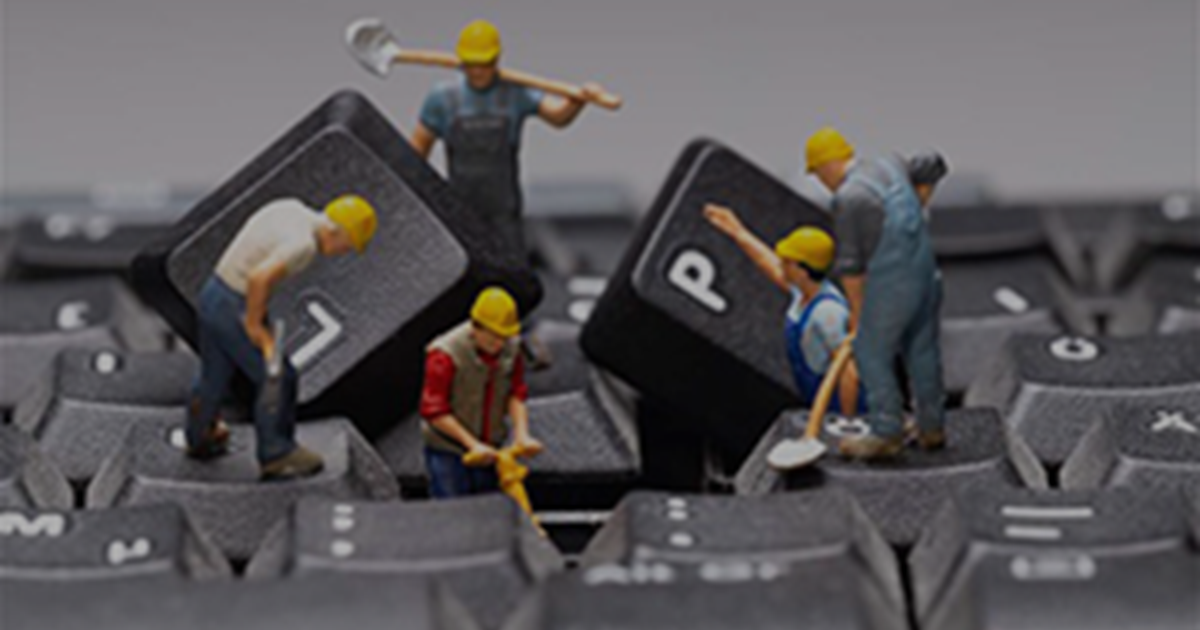 mini figurines construction workers taking apart a keyboard