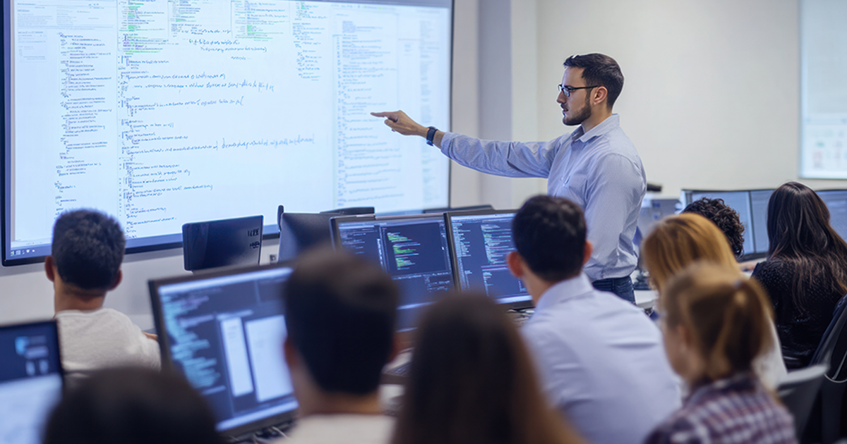 Man pointing at screen in front of class teaching cybersecurity